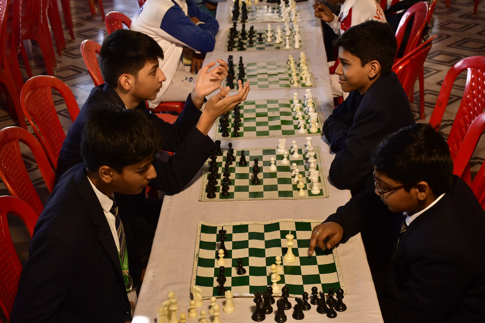 Students playing chess and focusing on their strategy at the Bal Vidyalaya Chess Championship event.