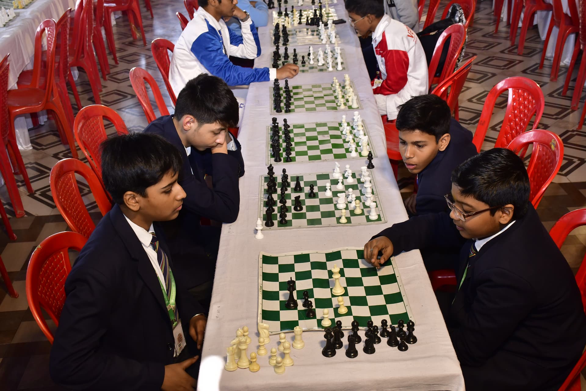 Students playing chess and focusing on their strategy at the Bal Vidyalaya Chess Championship event.