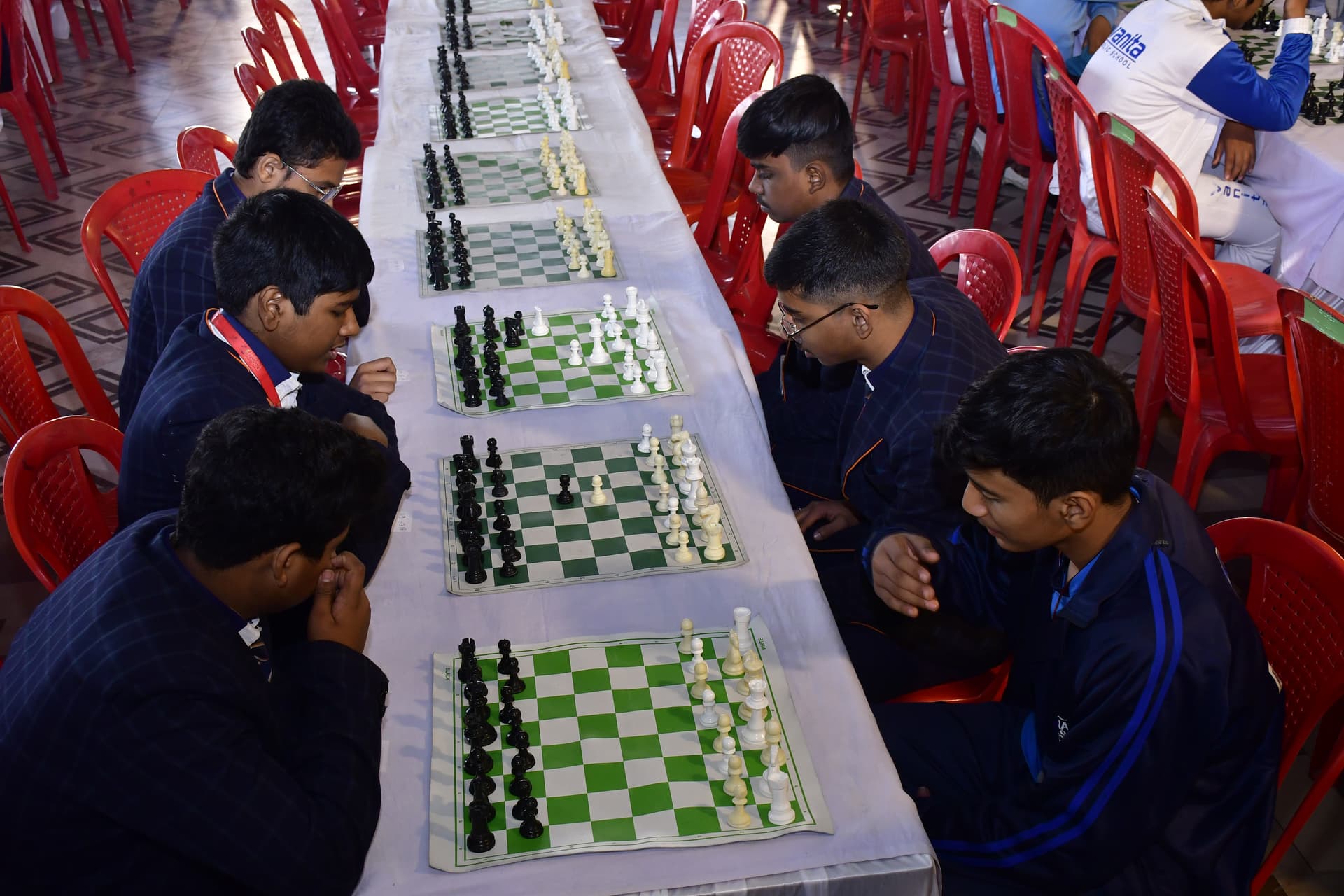 Students playing chess and focusing on their strategy at the Bal Vidyalaya Chess Championship event.