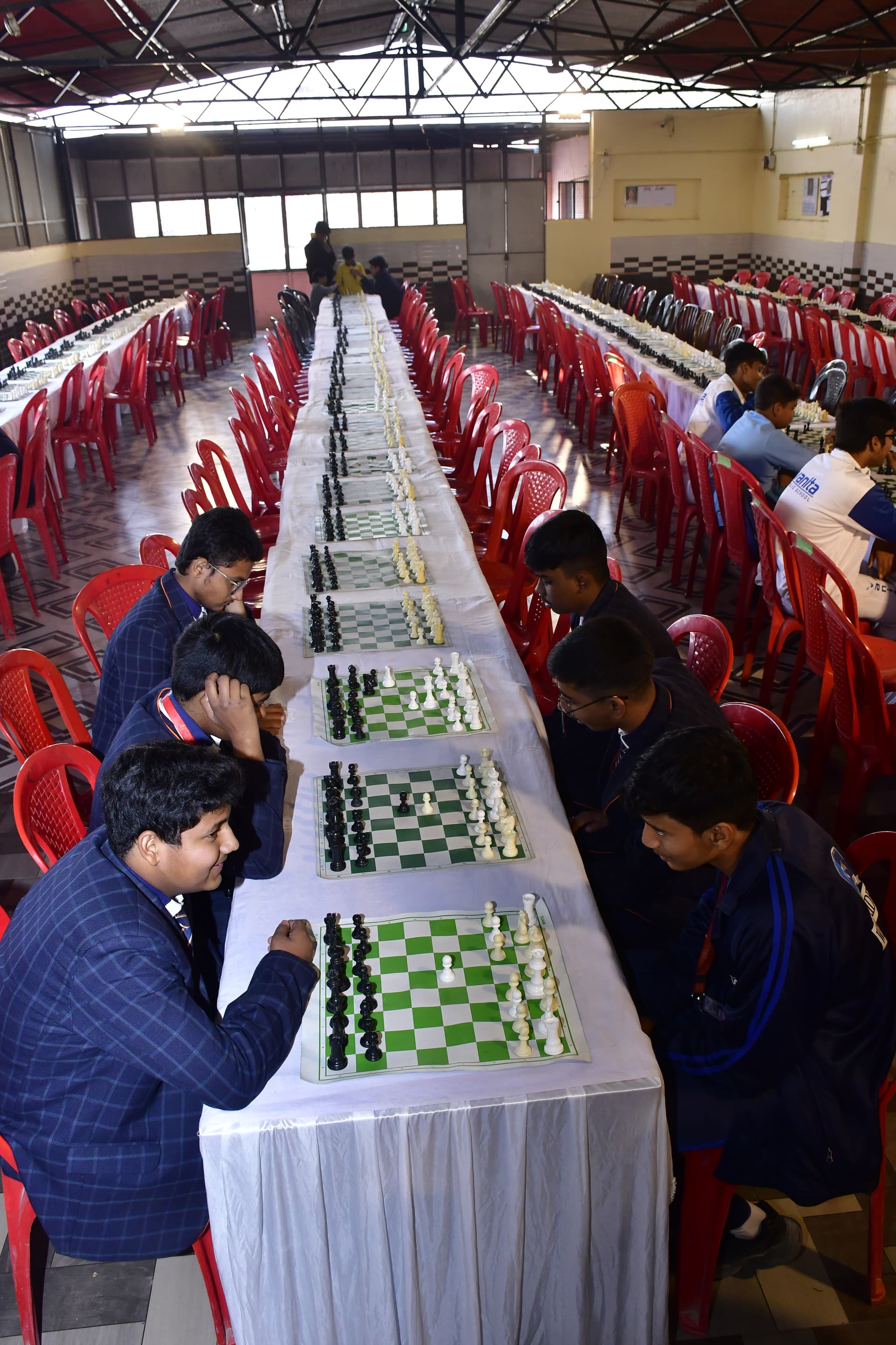 Students playing chess and focusing on their strategy at the Bal Vidyalaya Chess Championship event.