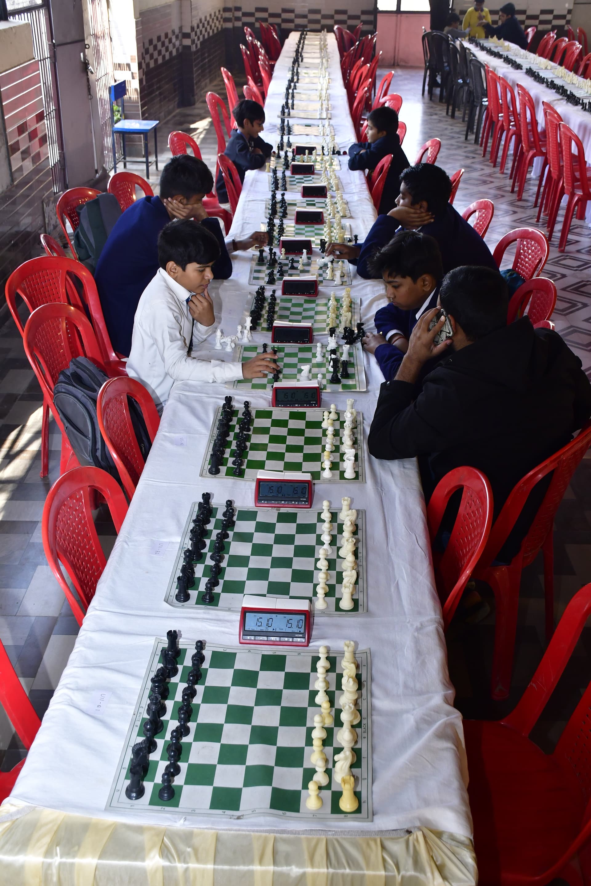 Students playing chess and focusing on their strategy at the Bal Vidyalaya Chess Championship event.