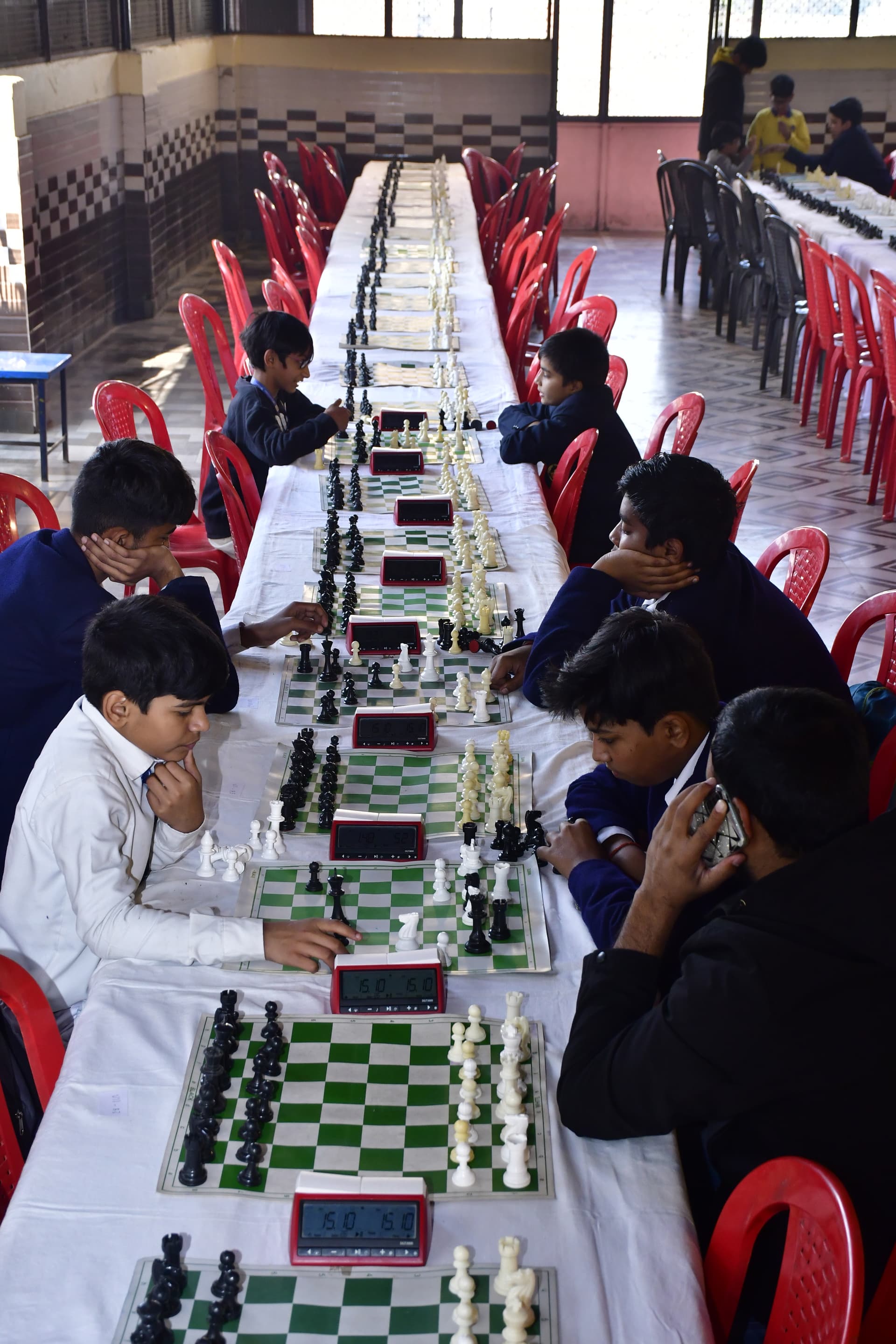Students playing chess and focusing on their strategy at the Bal Vidyalaya Chess Championship event.