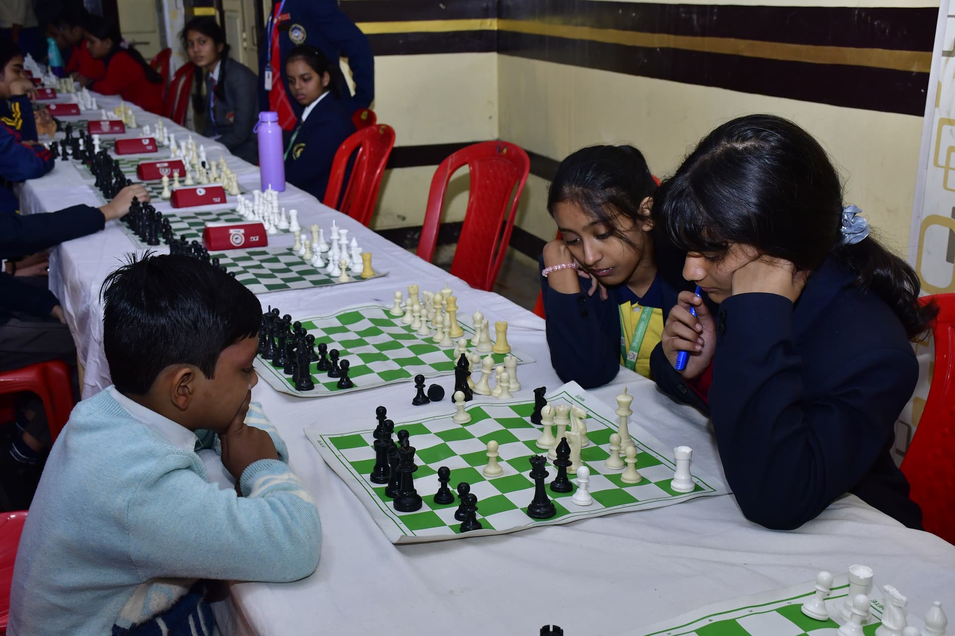 Students playing chess and focusing on their strategy at the Bal Vidyalaya Chess Championship event.