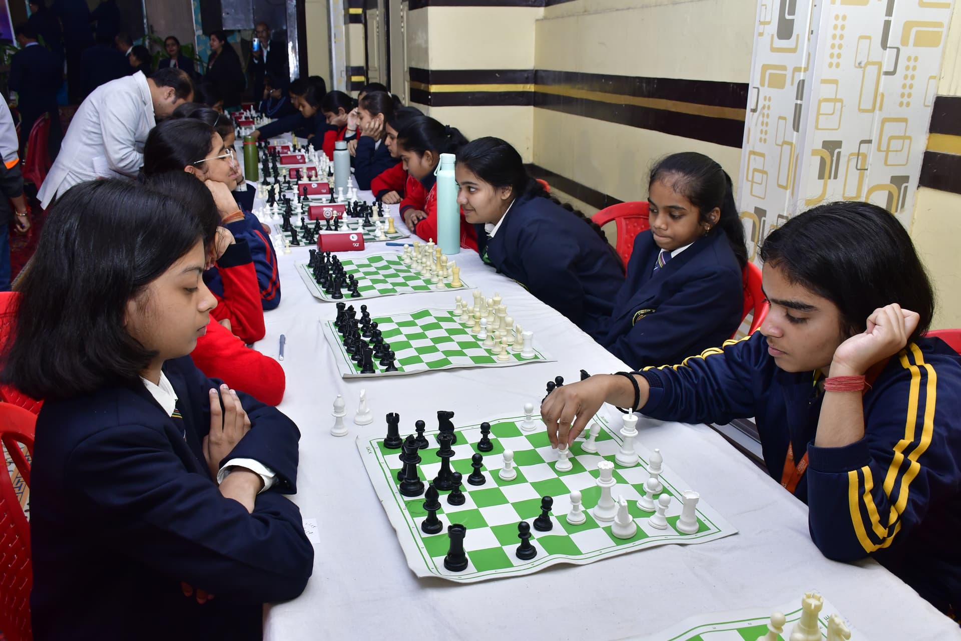 Students playing chess and focusing on their strategy at the Bal Vidyalaya Chess Championship event.