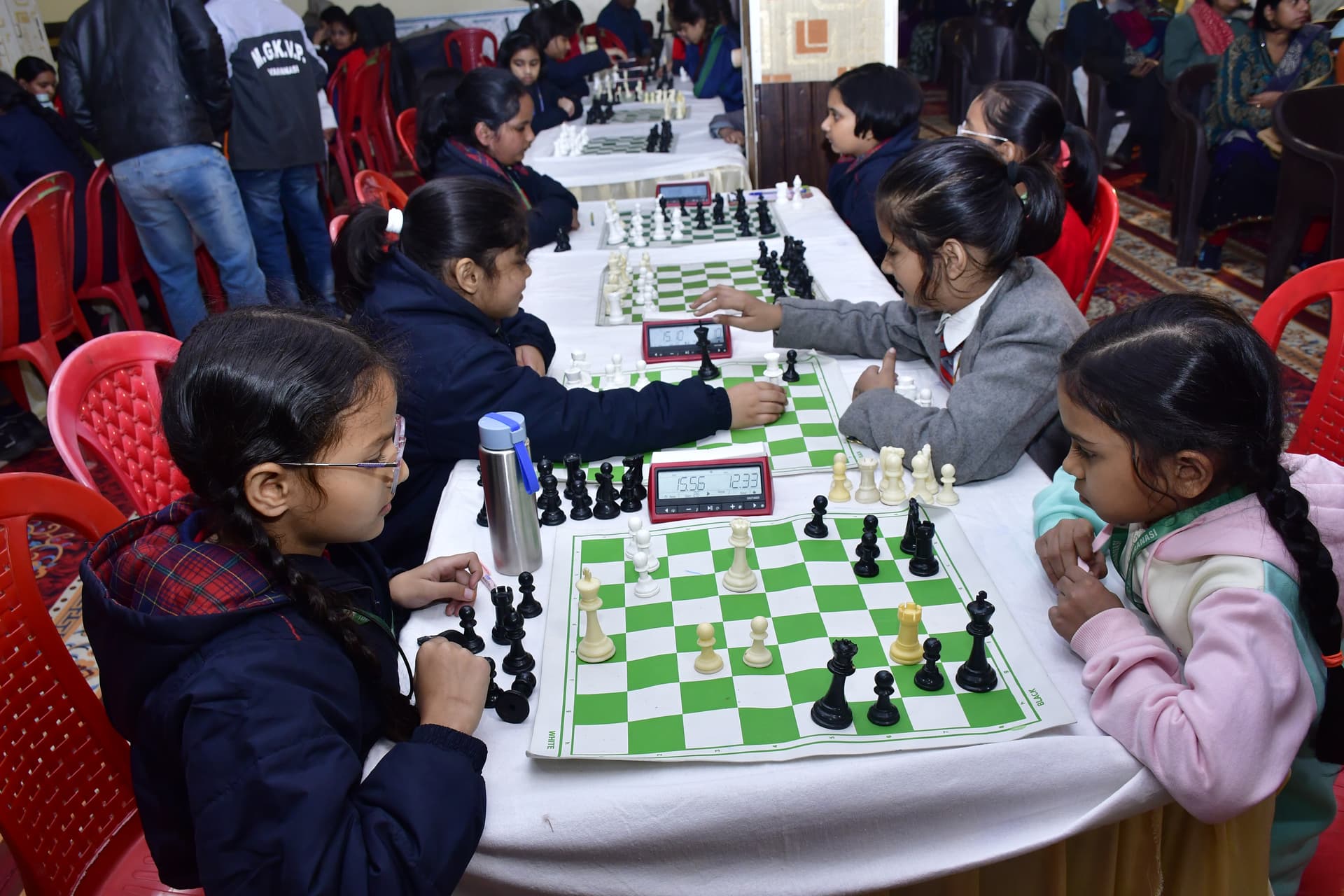 Students playing chess and focusing on their strategy at the Bal Vidyalaya Chess Championship event.