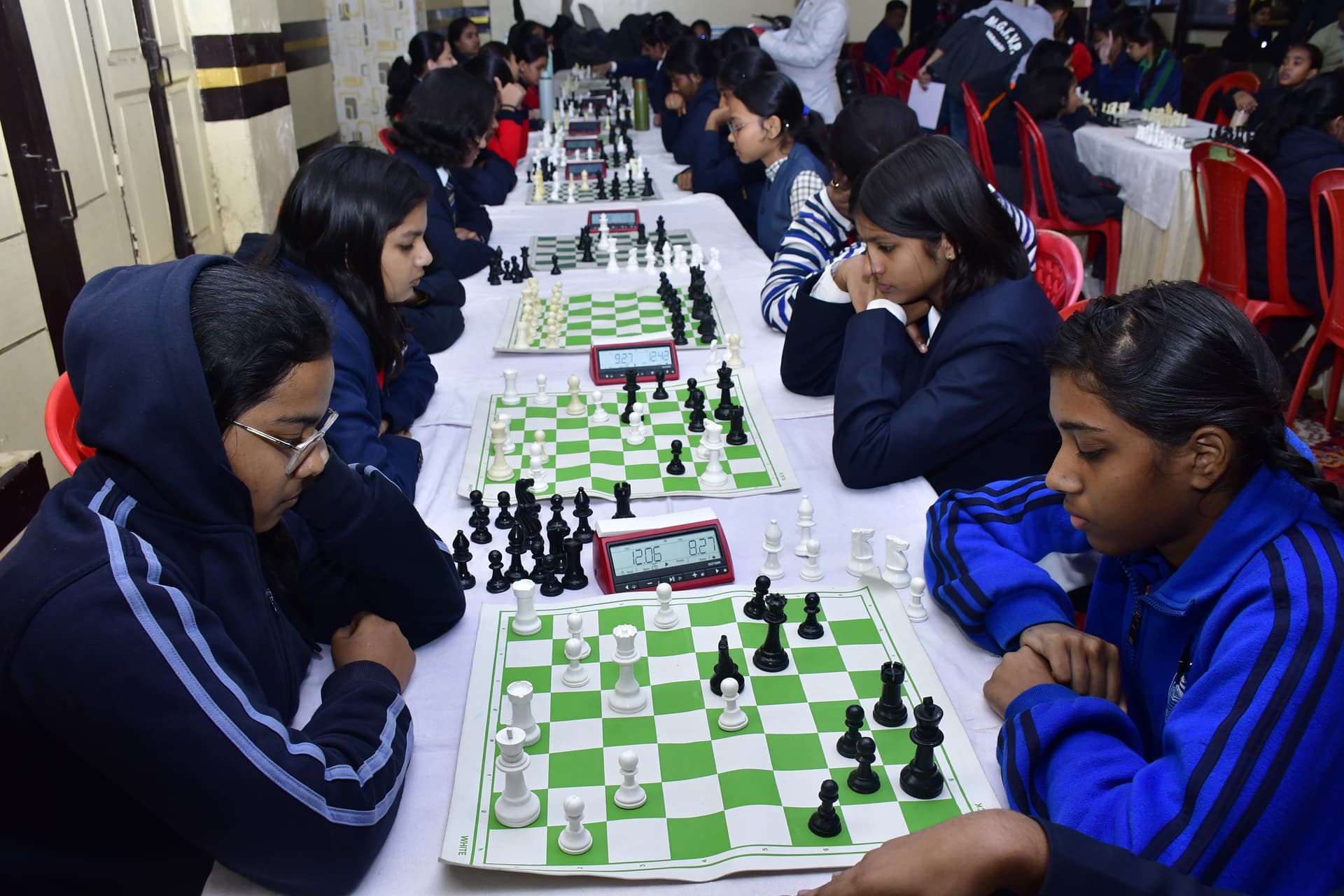Students playing chess and focusing on their strategy at the Bal Vidyalaya Chess Championship event.