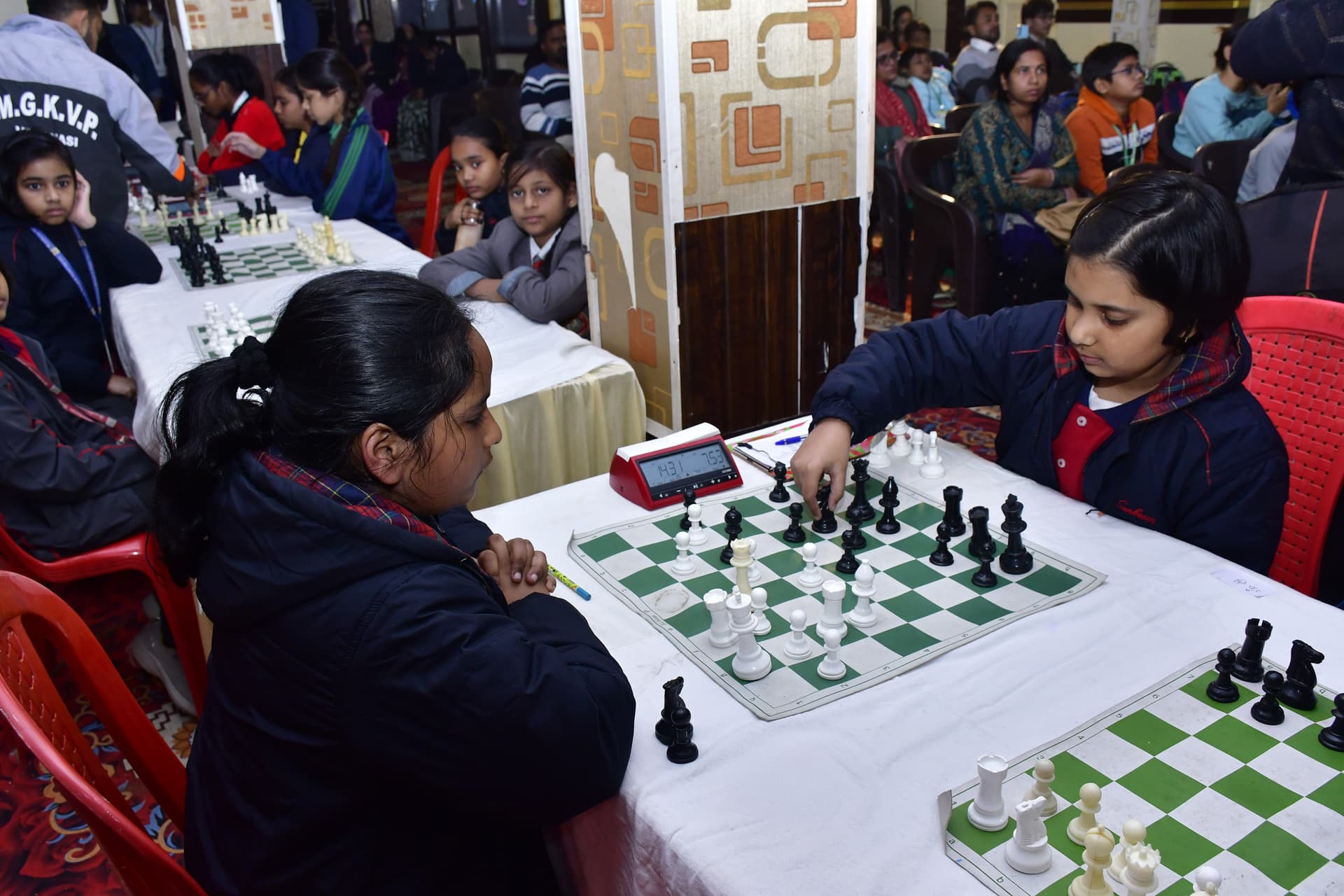 Students playing chess and focusing on their strategy at the Bal Vidyalaya Chess Championship event.