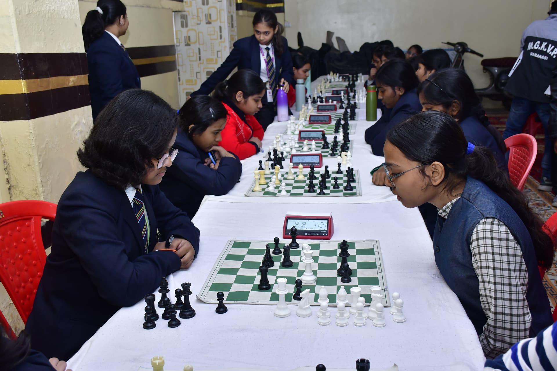 Students playing chess and focusing on their strategy at the Bal Vidyalaya Chess Championship event.