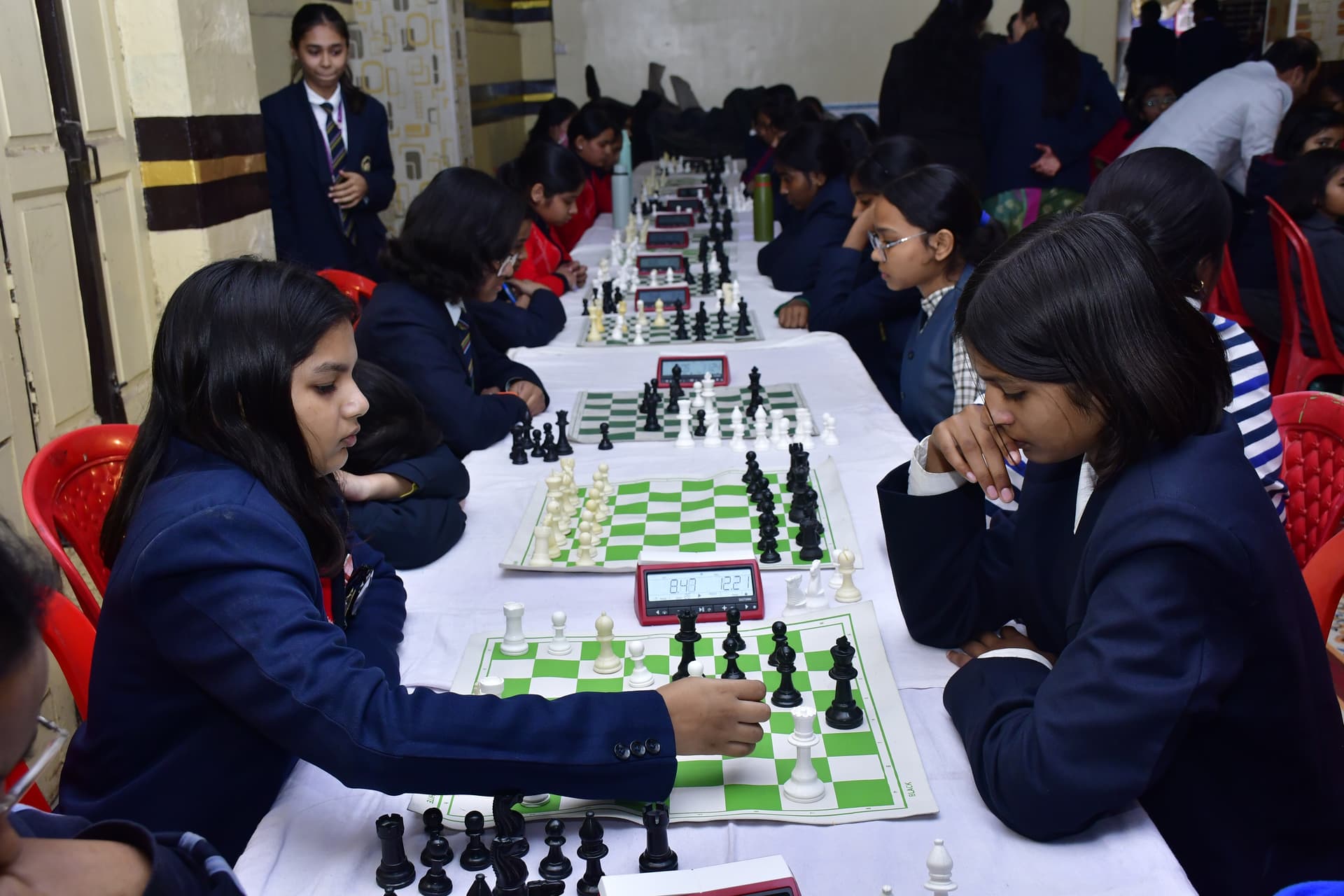 Students playing chess and focusing on their strategy at the Bal Vidyalaya Chess Championship event.